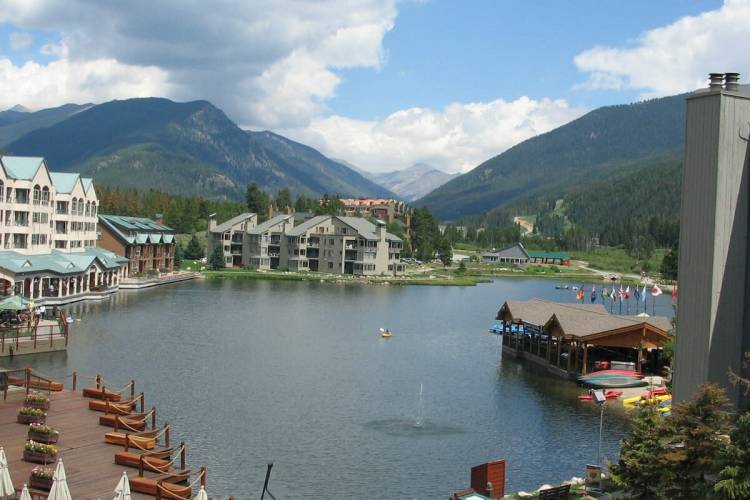small lake nestled in the mountains surrounded by beautiful views and apartment buildings